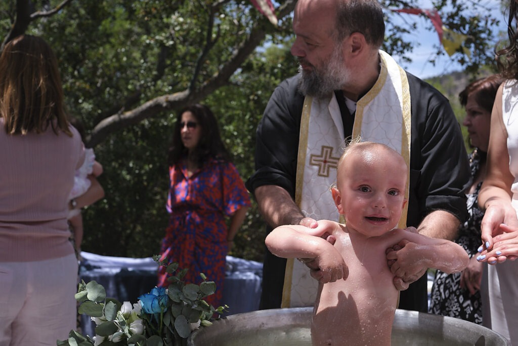 η στιγμή της βάπτισης στην κολυμπήθρα